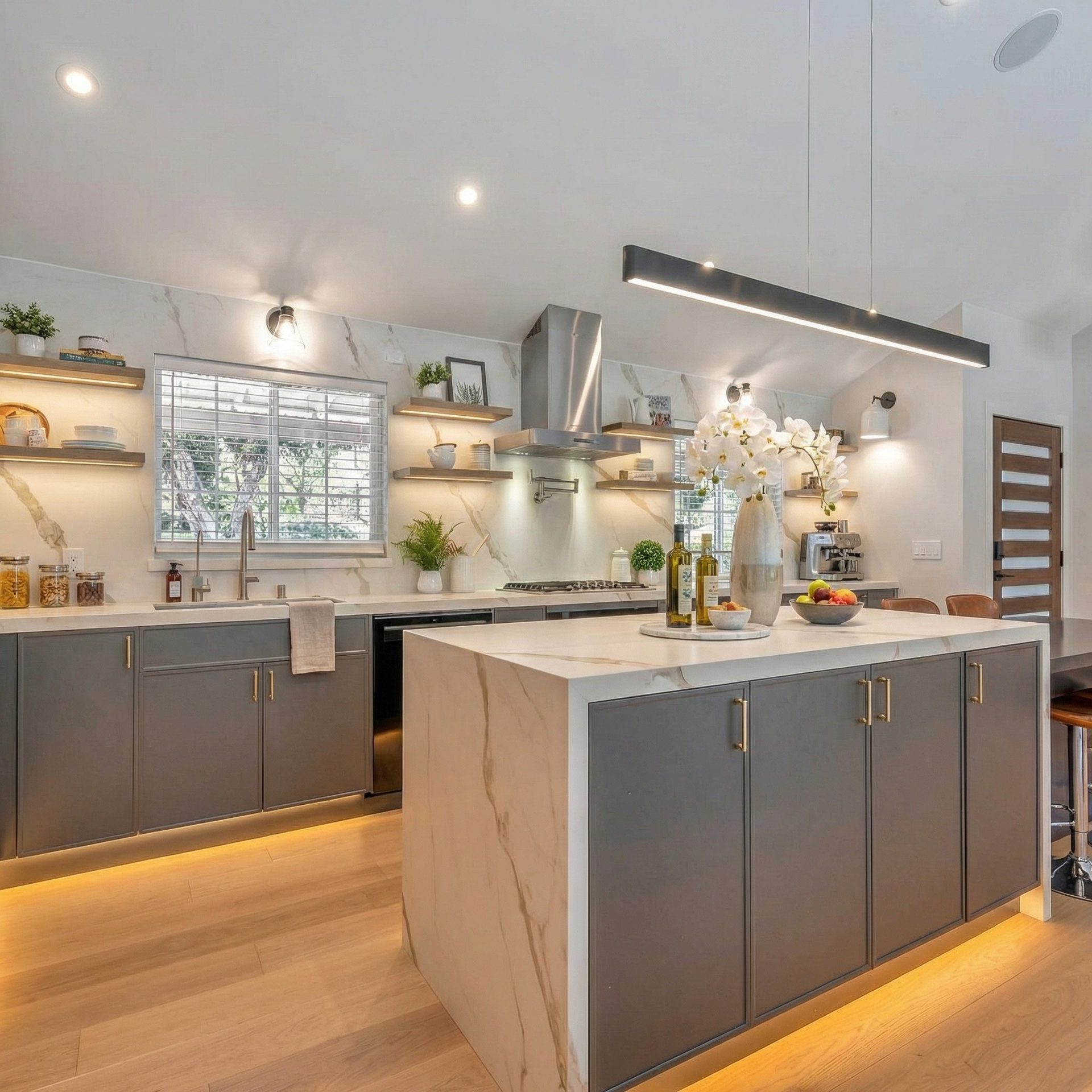 Warm contemporary kitchen with veined marble island and natural light